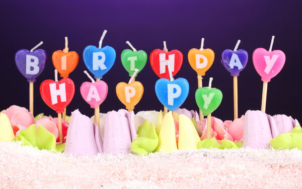 Birthday cake with candles on violet background