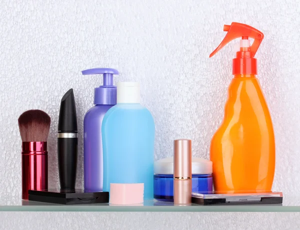 Shelf with cosmetics and toiletries in bathroom — Stock Photo, Image