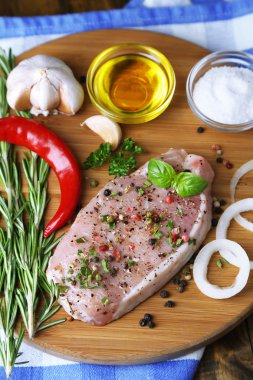 Otlar ve baharatlar ahşap arka plan üzerinde kesme tahtası üzerinde çiğ et biftek