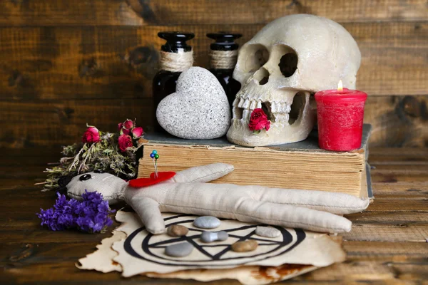 Konzeptionelles Foto von Liebeszauber. Komposition mit Totenkopf, Voodoo-Puppe, getrockneten Kräutern und Kerze auf dunklem Holzgrund — Stockfoto