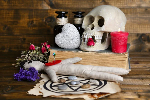 Conceptual photo of love magic. Composition with skull, voodoo doll, dried herbs and candle on  dark wooden background — Stock Photo, Image