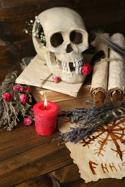 Conceptual photo of love magic. Composition with skull, voodoo doll, dried herbs and candle on  dark wooden background — Stock Photo, Image