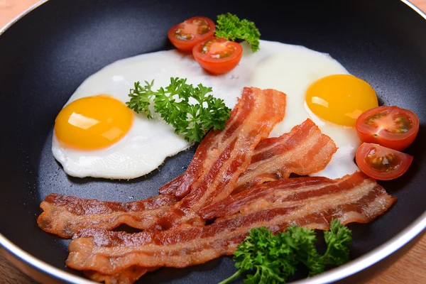 Ovos mexidos e bacon na frigideira em close-up de mesa — Fotografia de Stock
