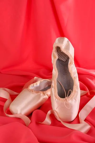 Zapatillas de punto de ballet sobre fondo de tela roja — Foto de Stock