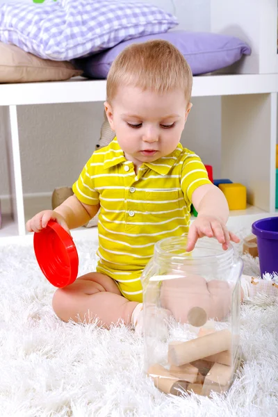 Söt liten pojke med trä leksak blockerar i rum — Stockfoto