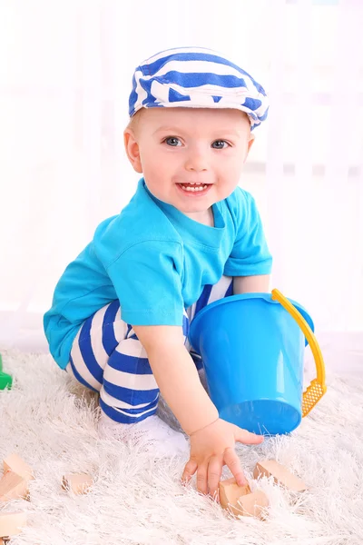 Lindo niño con bloques de juguete de madera en la habitación — Foto de Stock