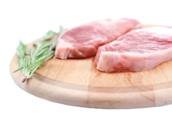 Rohes Fleischsteak mit Kräutern auf Schneidebrett, isoliert auf weißem — Stockfoto