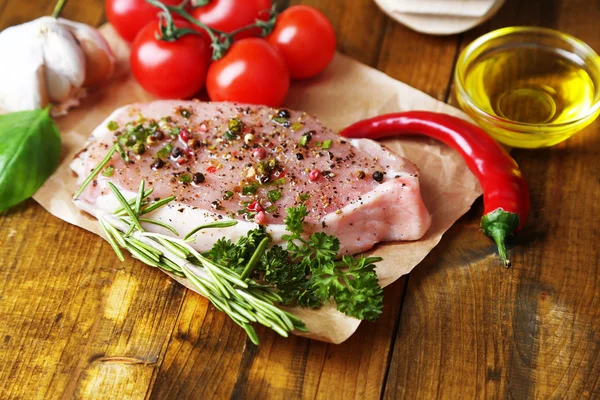 Bife de carne crua com ervas de especiarias, sobre fundo de madeira — Fotografia de Stock