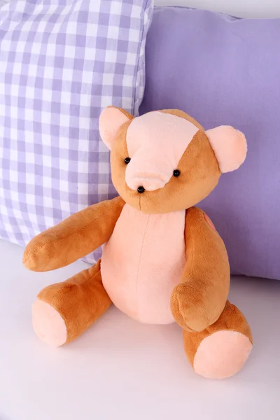 Медвежья игрушка с подушками на диване — стоковое фото