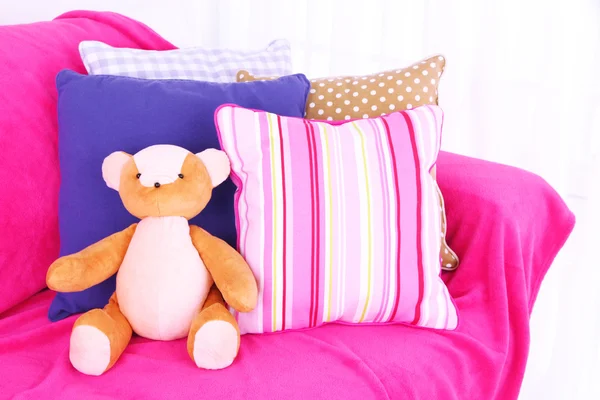 Bear toy with pillows on sofa — Stock Photo, Image