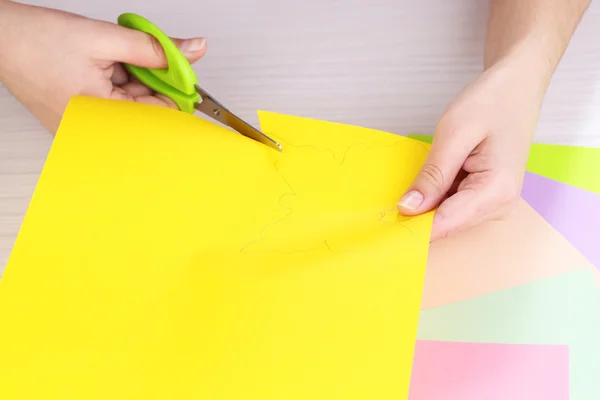 Women hand cutting colorful paper with scissors — Stock Photo, Image