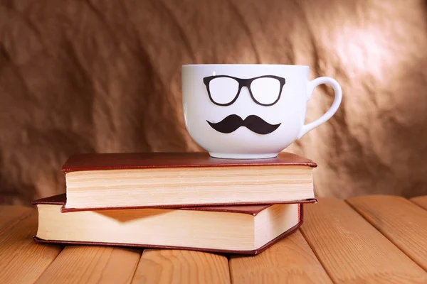 Tasse mit Schnurrbart auf Tisch auf braunem Hintergrund — Stockfoto