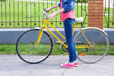 Dışarıda bisikleti olan genç bir kadın.