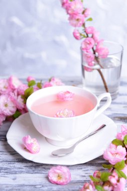 Güzel meyve çiçeği çay gri arka plan üzerinde tablo ile