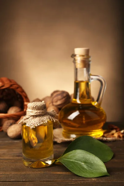 Notenolie en noten op houten tafel — Stockfoto