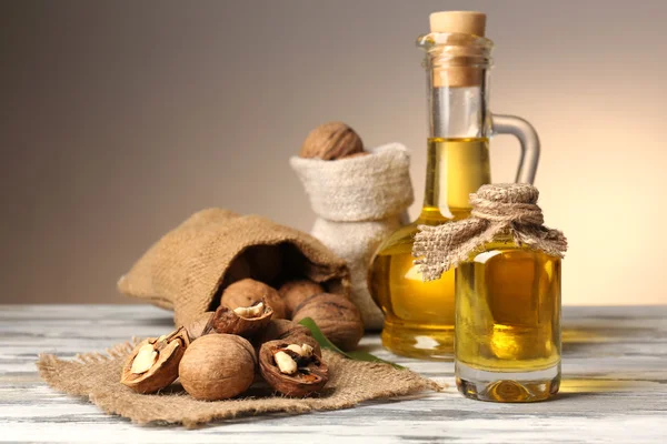 Ореховое масло и орехи на деревянном столе — стоковое фото