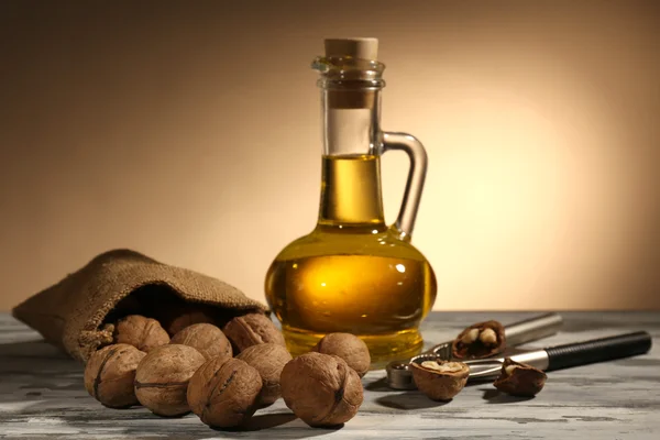 Walnut oil and nuts on wooden table — Stock Photo, Image