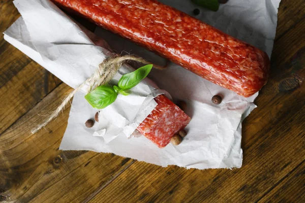 Sabrosa salchicha salami y especias sobre fondo de madera — Foto de Stock