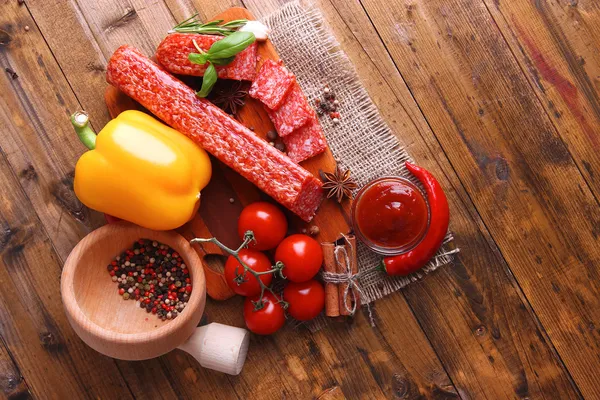 Savoureux saucisson salami et épices sur fond de bois — Photo