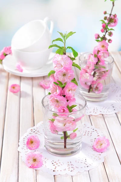 Mooie fruit blossom in glas op tafel op lichte achtergrond — Stockfoto