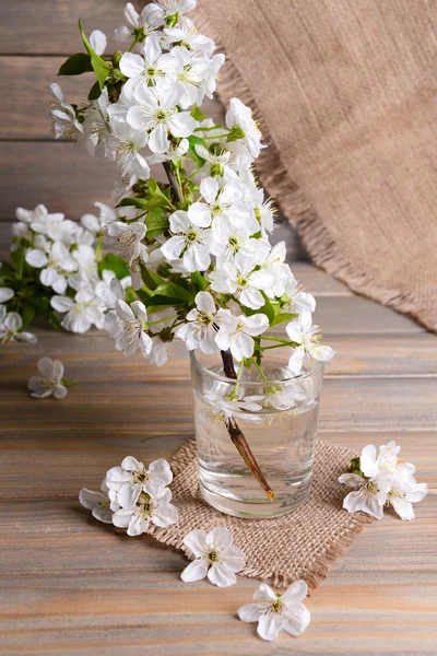 Hermosa flor de fruta en vidrio sobre mesa sobre fondo gris — Foto de Stock