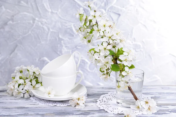 Mooie fruit blossom in glas op tafel op grijze achtergrond — Stockfoto