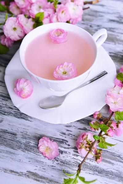 Beautiful fruit blossom with cup of tea on table close-up — Stock Photo, Image