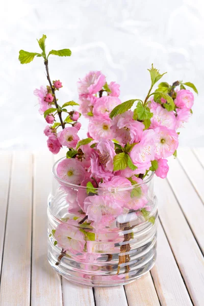 Schöne Obstblüte im Glas auf dem Tisch auf hellem Hintergrund — Stockfoto