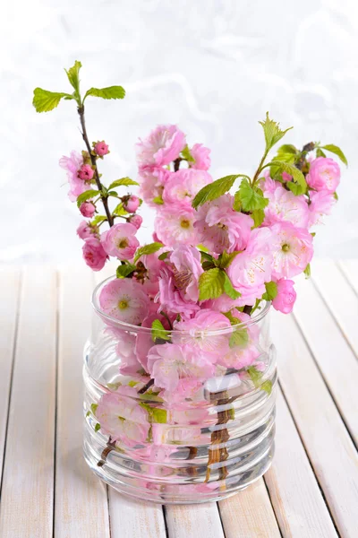 Beautiful fruit blossom in jar on table on light background — Stock Photo, Image