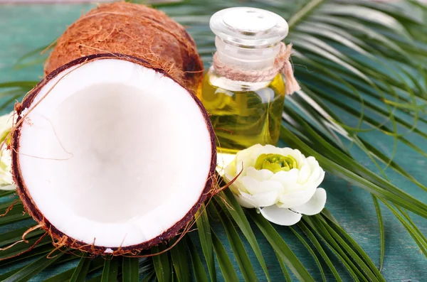 Cocos e óleo de coco sobre mesa de madeira — Fotografia de Stock