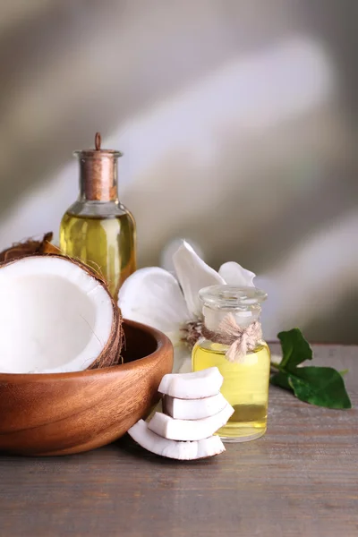 Coconuts and coconut oil on wooden table — Stock Photo, Image