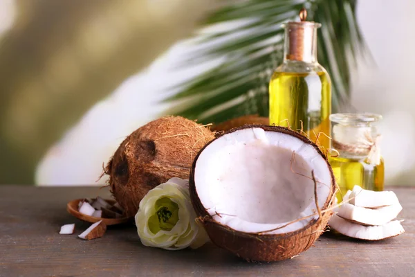 Cocos e óleo de coco sobre mesa de madeira — Fotografia de Stock