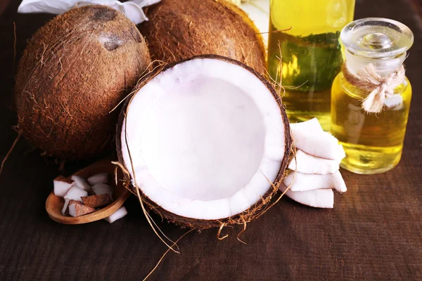 Cocos e óleo de coco sobre mesa de madeira — Fotografia de Stock