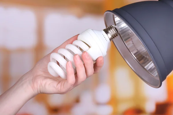 Hand changing light bulb for lamp at home