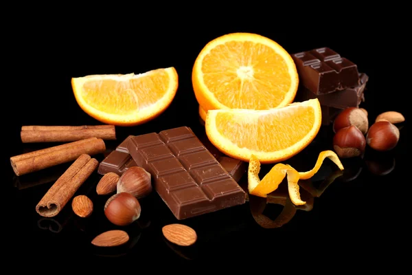 Čokoláda, oranžová a ořechy na černém pozadí — Stock fotografie