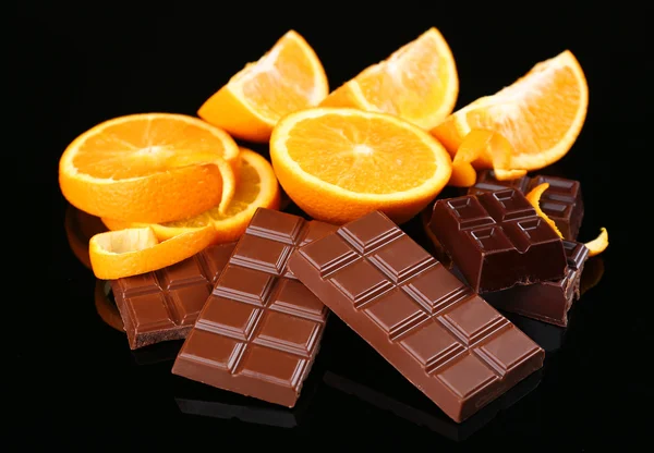 Шоколад и апельсин на черном фоне — стоковое фото