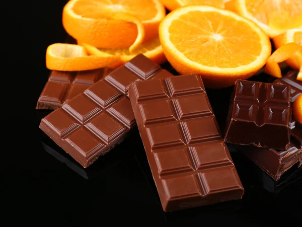 Čokoláda a pomeranč na černém pozadí — Stock fotografie