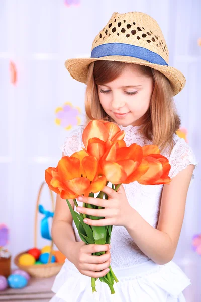 Beautiful small girl holding flowers on decorative background — Stock Photo, Image