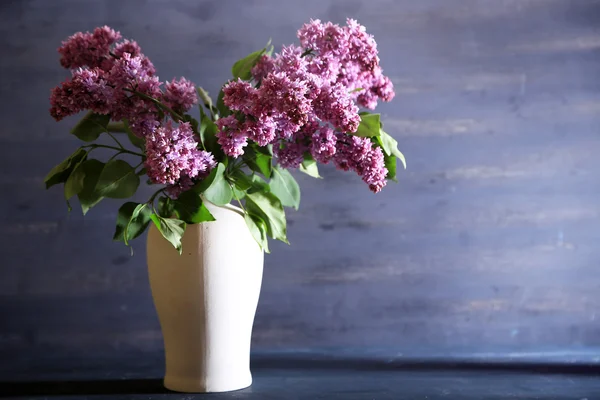 Lindas flores lilás em vaso, na cor de fundo de madeira — Fotografia de Stock