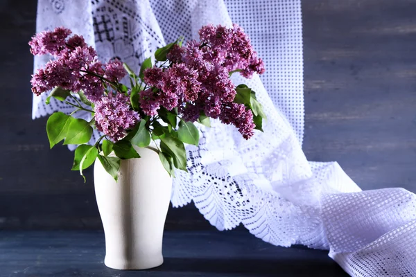 Güzel Eflatun çiçekler vazoda renkli ahşap zemin üzerinde — Stok fotoğraf