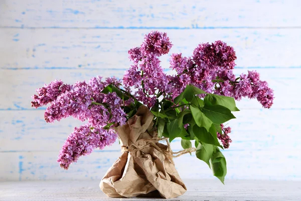 Hermosas flores lila en jarrón, sobre fondo de madera de color — Foto de Stock