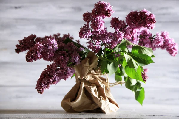 Bellissimi fiori lilla in vaso, su sfondo di legno a colori — Foto Stock