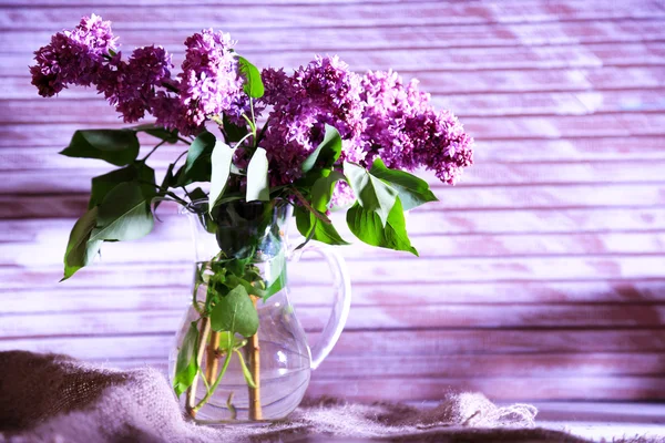 Lindas flores lilás em vaso, na cor de fundo de madeira — Fotografia de Stock