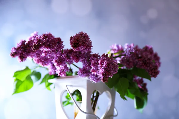 Bellissimi fiori lilla in vaso, su tavolo di legno, su sfondo colore — Foto Stock