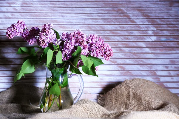 Lindas flores lilás em vaso, na cor de fundo de madeira — Fotografia de Stock