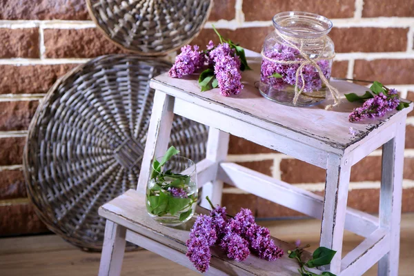 色の壁の背景上の木製の梯子の上の花瓶に美しいライラック色の花 — ストック写真
