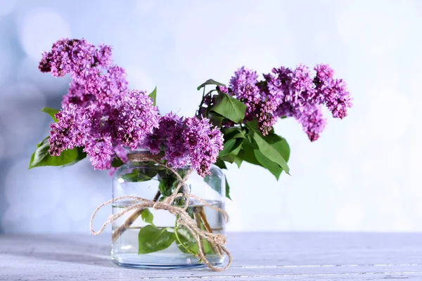 Smukke lilla blomster i vase, på farve træbord, på lys baggrund - Stock-foto