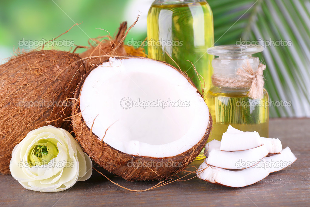Coconuts and coconut oil on wooden table, on nature background — Stock