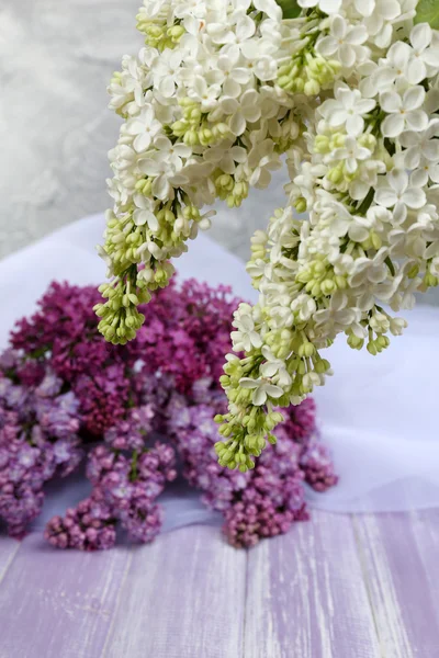 Beautiful lilac flowers on wooden table — Stock Photo, Image