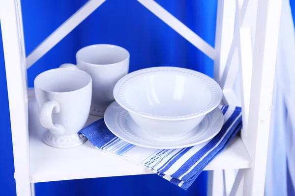 Magnifiques étagères blanches avec vaisselle et décor sur fond de couleur — Photo